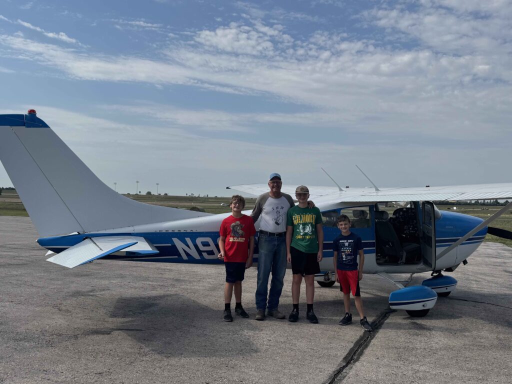 FlyBadlands tour with father and kids in front of plane